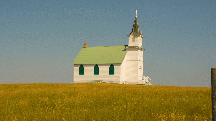A white country church on a grassy prairie invokes the idea of religious land use protections.